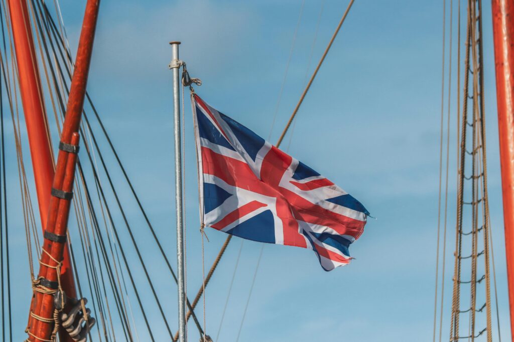 Union Jack flag waving prominently from a ship mast, capturing a sense of travel and patriotism.