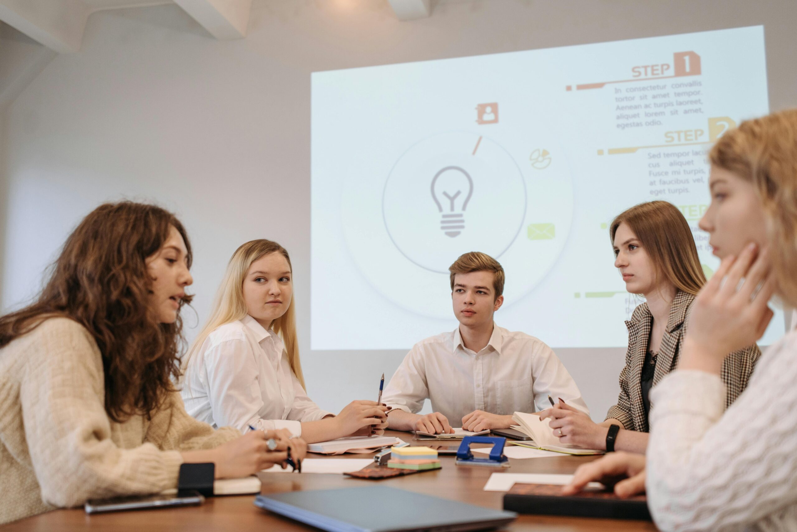A diverse group of young professionals in an office discussing a business presentation.